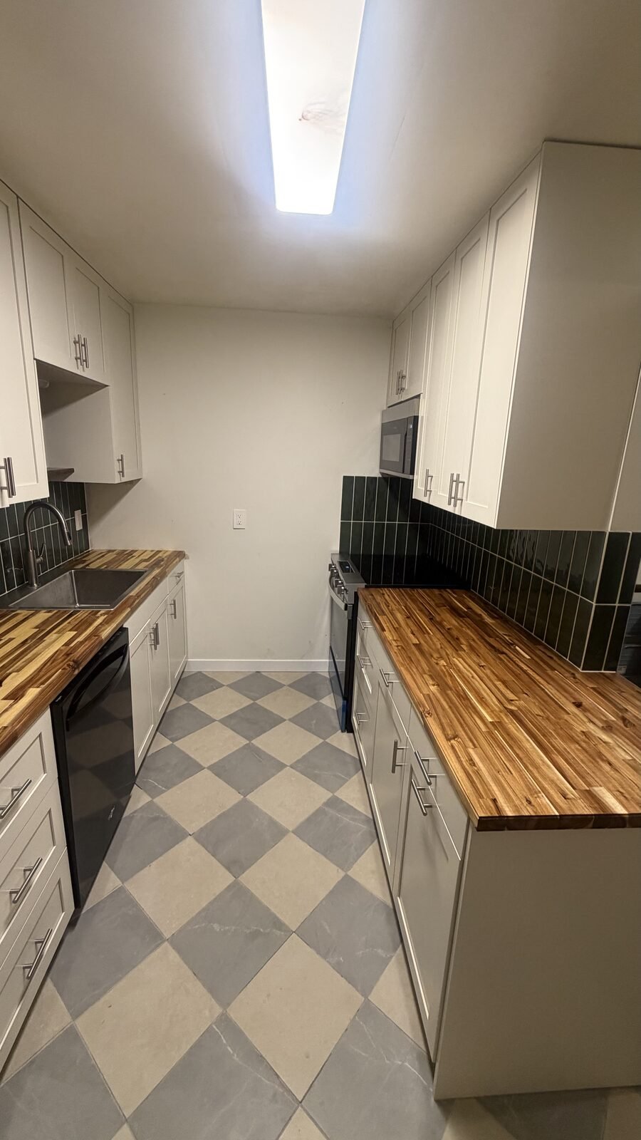 Madison WI kitchen after remodel — galley layout with butcher-block counters, green tile backsplash, and checkerboard tile floor