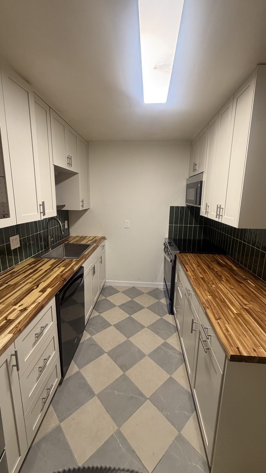 Madison WI kitchen after remodel — stainless range with green tile backsplash, white shaker cabinets, and butcher-block counters